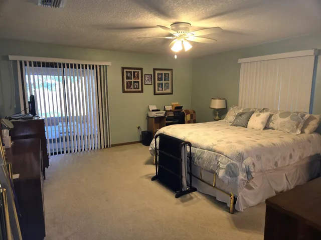 a spacious bedroom with a bed and a chandelier