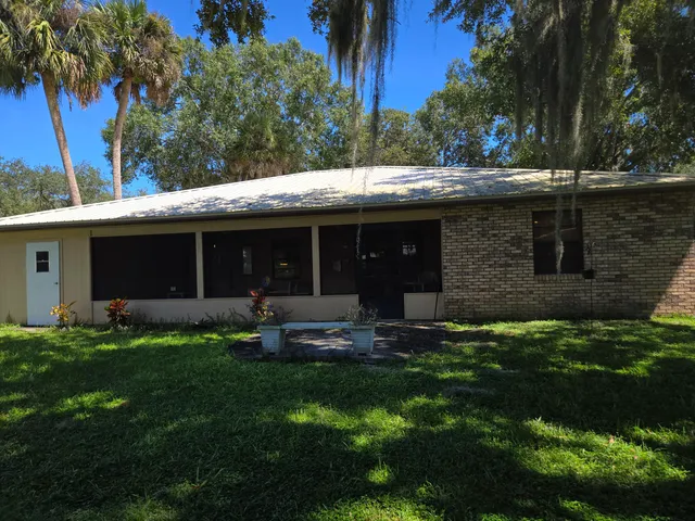a view of a house with a yard and sitting area