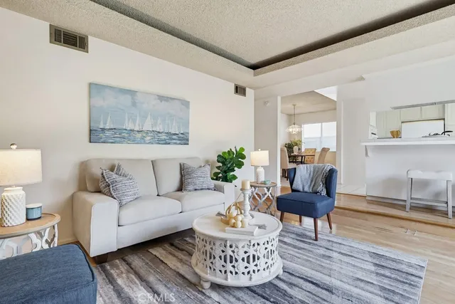 a living room with furniture a lamp paintings and a window