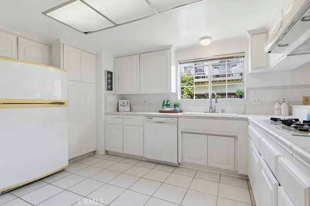 a kitchen with white cabinets and white appliances