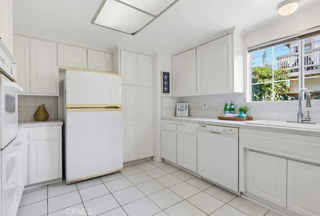 a kitchen with a refrigerator and white cabinets