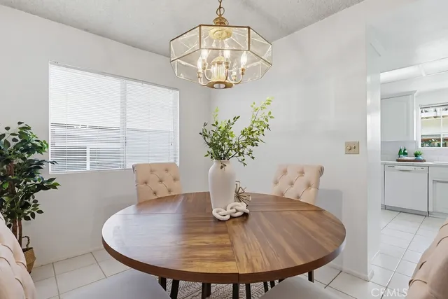 a dining room with furniture a potted plant and a chandelier