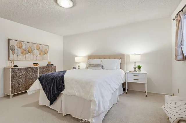 a bedroom with a bed and a painting on the wall