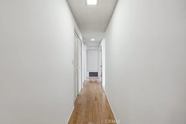 a view of a hallway with wooden floor