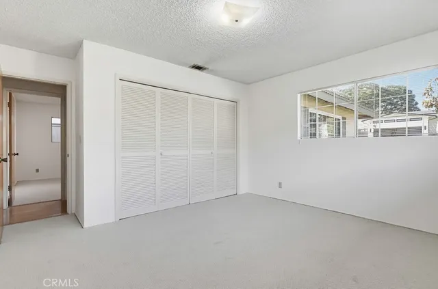 an empty room with windows and closet
