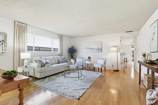 a living room with furniture wooden floor and a large window