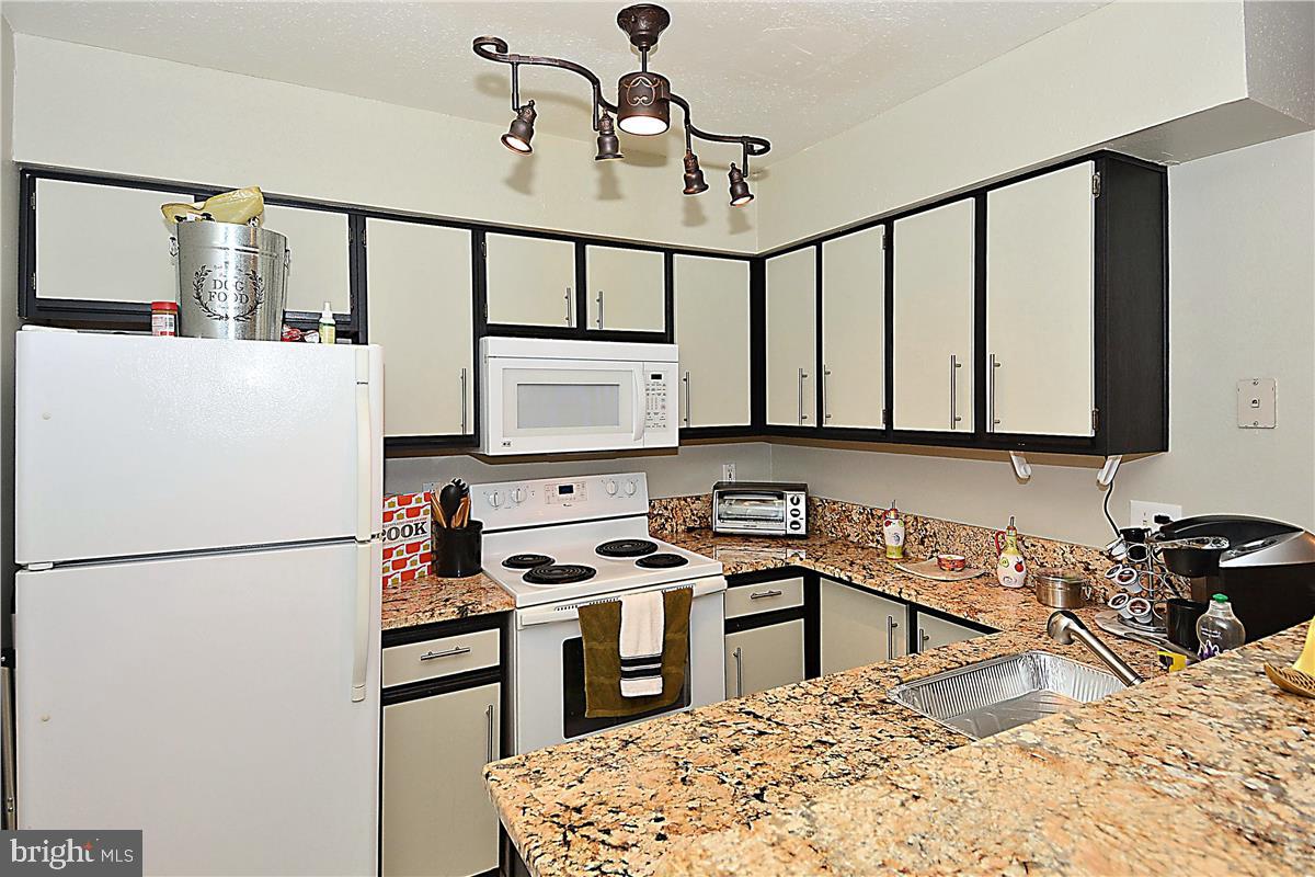 3305 Wyndham Circle, Unit 252 Alexandria, VA 22302 - Photo 14 of 20 a kitchen with stainless steel appliances granite countertop a sink stove and refrigerator