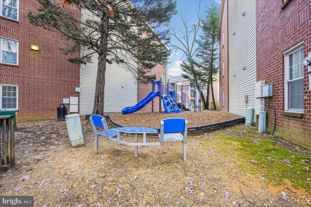 3305 Wyndham Circle, Unit 252 Alexandria, VA 22302 - Photo 4 of 20 a view of a house with a yard fire pit and a bench