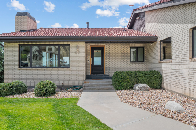 4221 Juniper Circle Alpine, UT 84004 - Photo 43 of 66 Light brick exterior featuring a red tile roof, black-framed windows, and a dark entry door