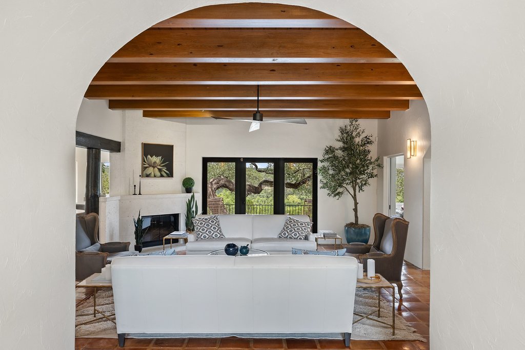 716 North Commons Ford Road Austin, TX 78733 - Photo 3 of 30 Vaulted ceiling with exposed wood beams, a built-in fireplace, and expansive black-framed glass doors