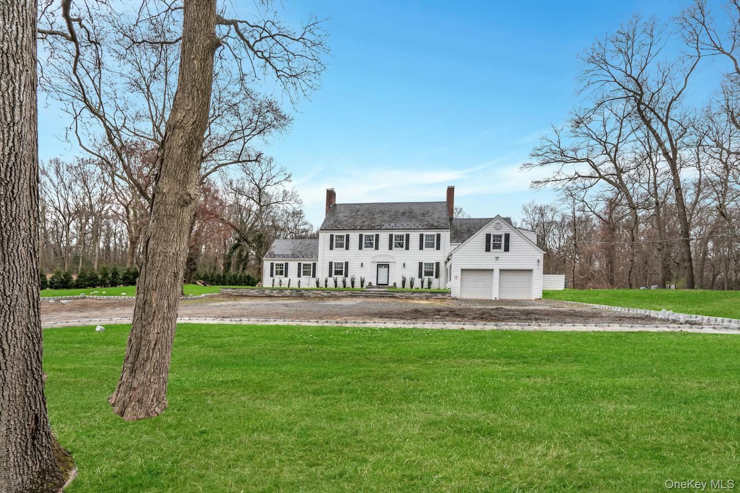 539 Split Rock Road Syosset, NY 11791 - Photo 40 of 40 View of front facade featuring a chimney, a front yard, and a garage