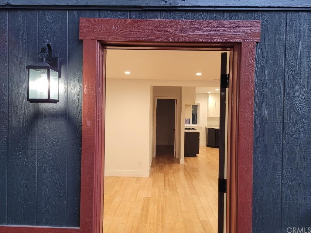 582 Sunset View Road Twin Peaks, CA 92391 - Photo 5 of 18 a view of a hallway with wooden floor and a living room
