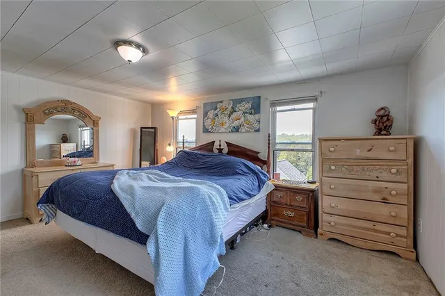 a spacious bedroom with a bed and a dresser