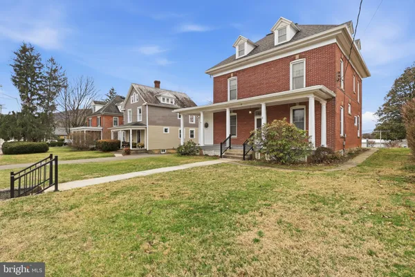 an empty room with chandelier fan and windows