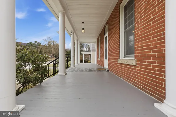 a view of an empty room with chandelier fan and fire place