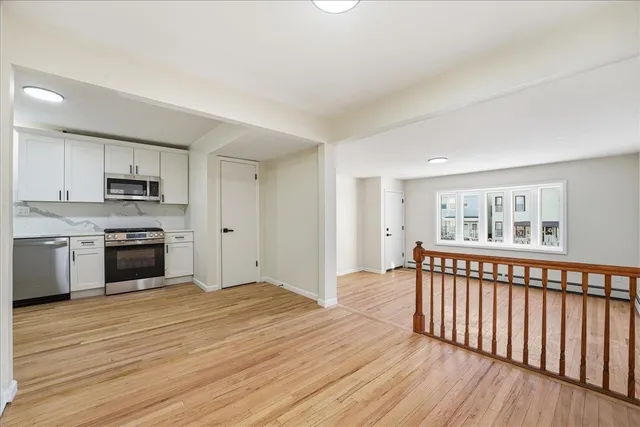 a view of a kitchen with wooden floor and electronic appliances