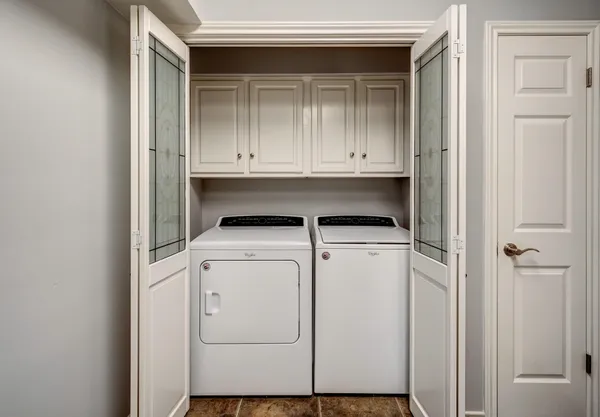 an empty room with chandelier fan and windows