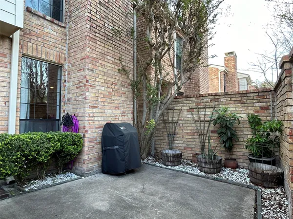 a couple of potted plants in front of brick building