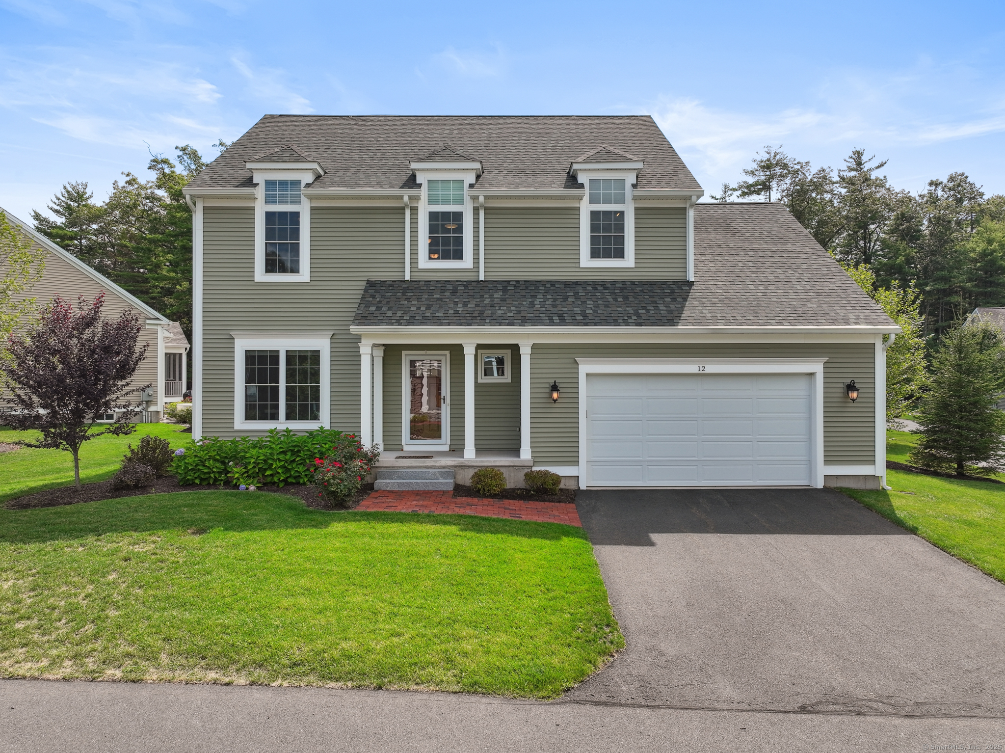 12 Prospect Ridge, Unit 12 Simsbury, CT 06070 - Photo 1 of 1 a front view of a house with a garden and yard
