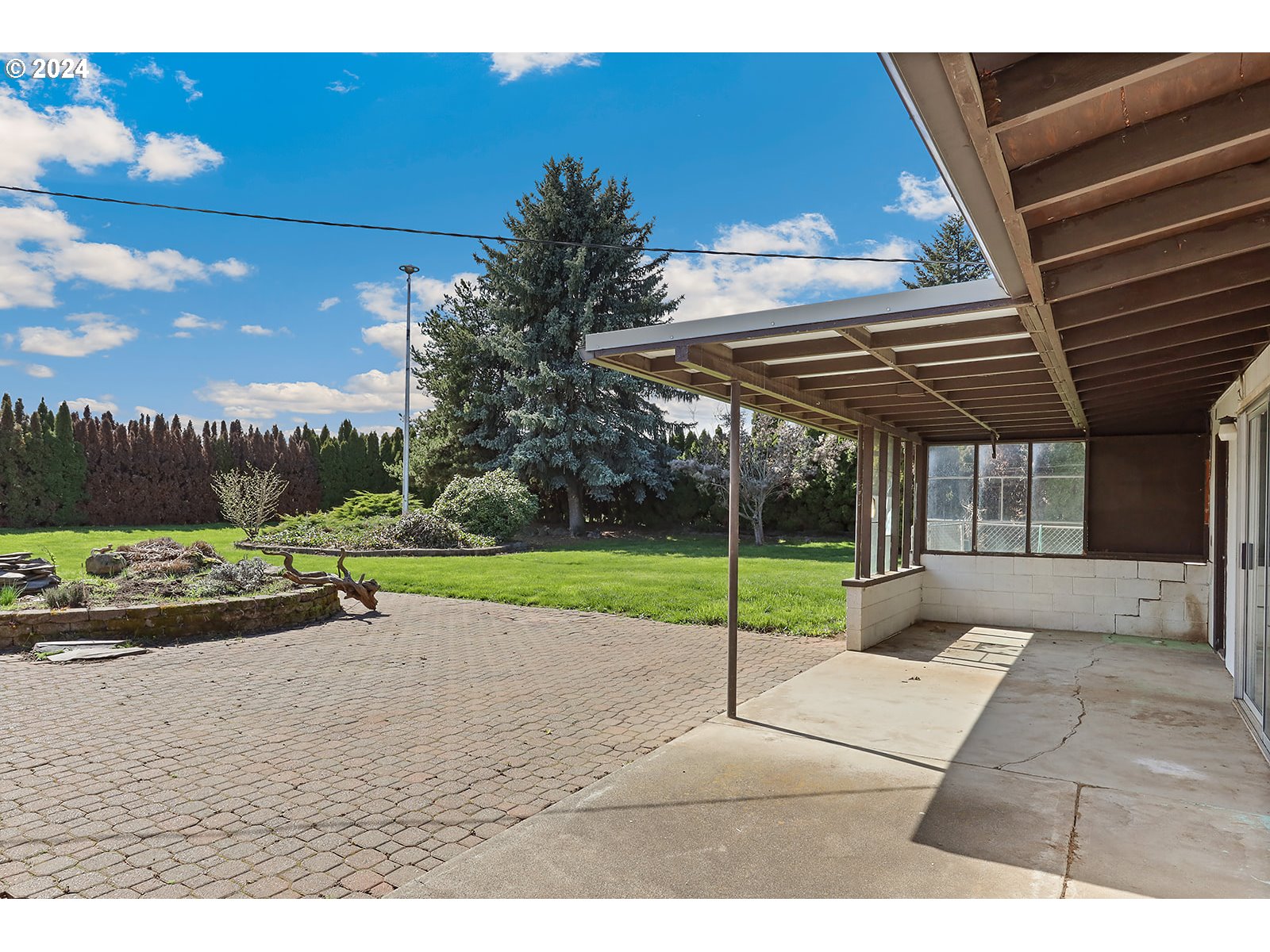 1465 Tucker Road Hood River, OR 97031 - Photo 35 of 48 a view of a backyard with table and chairs under an umbrella with a small yard