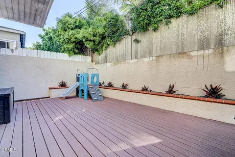 a view of a terrace with wooden floor and a large tree