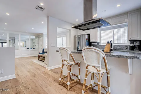 a kitchen with granite countertop a table chairs microwave a sink and cabinets