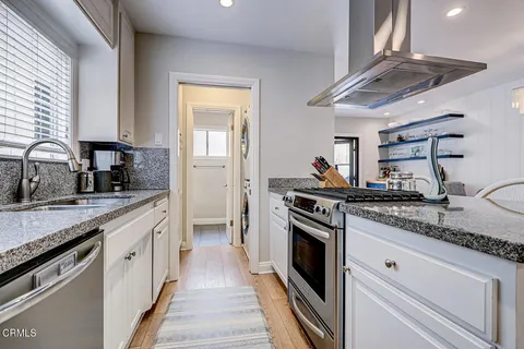 a kitchen with stainless steel appliances granite countertop a sink and stove