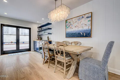 a view of a dining room with furniture a chandelier and wooden floor
