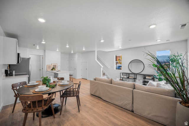2216 Wolverine Way Washington, UT 84780 - Photo 2 of 29 Spacious open-concept living area featuring wood-finish flooring, recessed lighting, and a kitchen island with a sink
