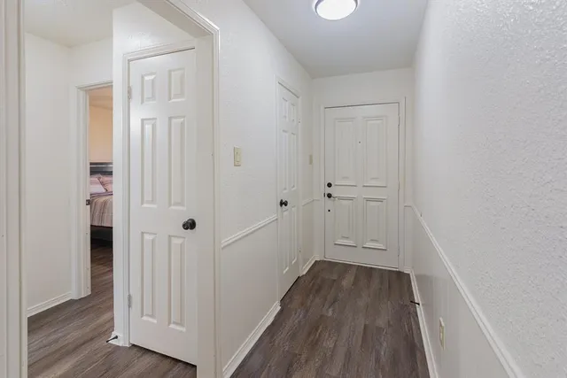 a view of a hallway with wooden floor and closet