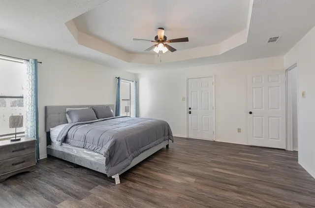 a bedroom with a large bed and a ceiling fan
