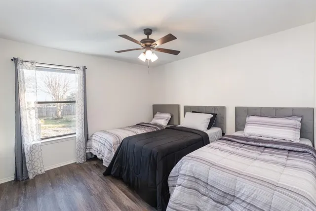a bedroom with two large bed and a window