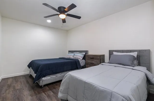 a bedroom with two beds and a ceiling fan