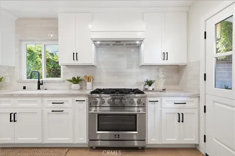 a kitchen with white cabinets and appliances