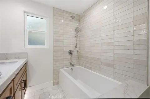a bathroom with a tub a sink a vanity and a shower