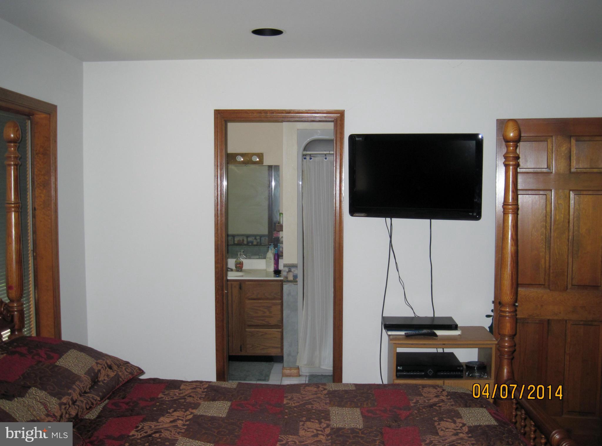 7151 Marshall Road St. Leonard, MD 20685 - Photo 15 of 25 a bedroom with a bed and a flat screen tv