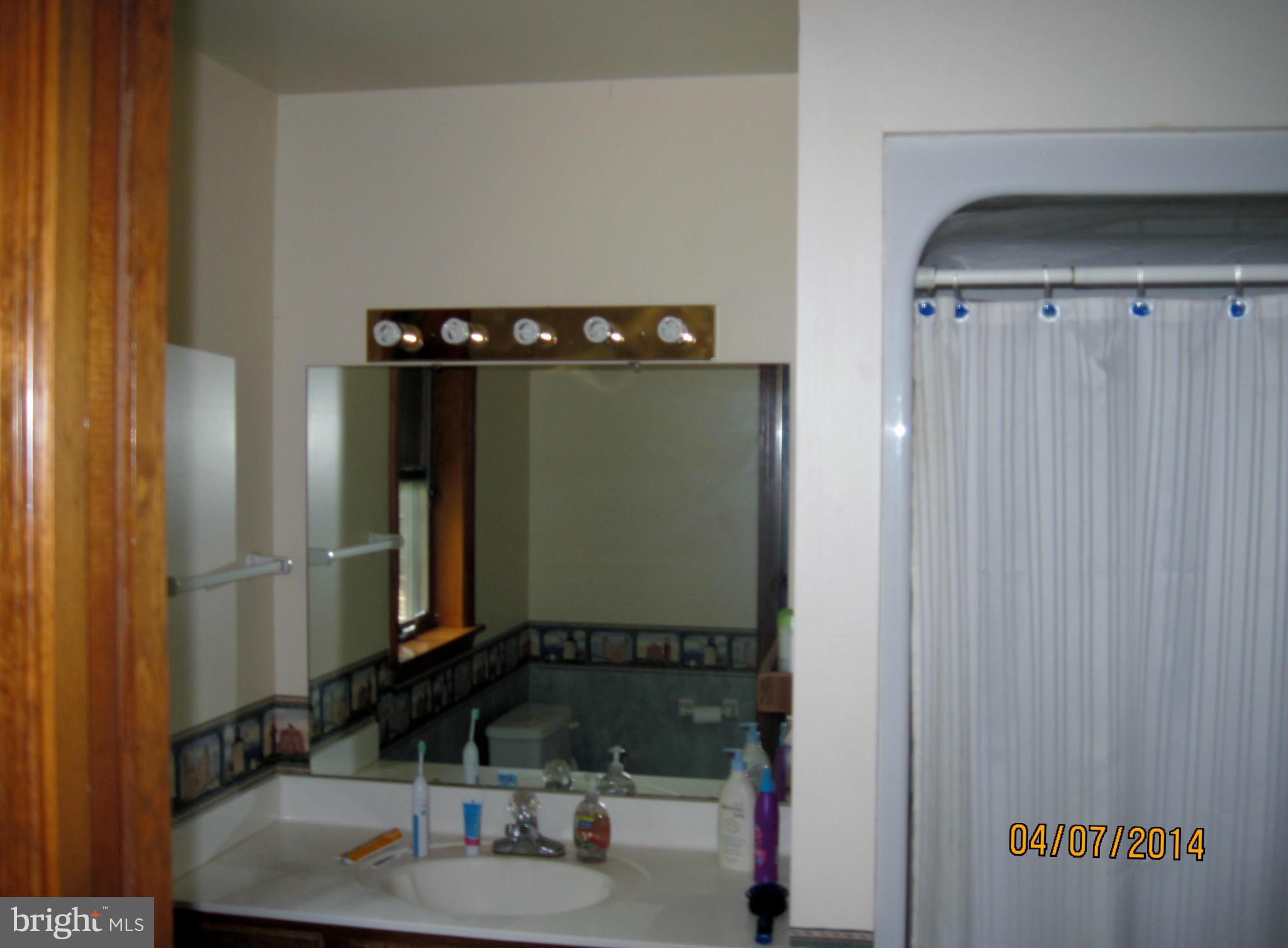 7151 Marshall Road St. Leonard, MD 20685 - Photo 16 of 25 a bathroom with a sink and a mirror