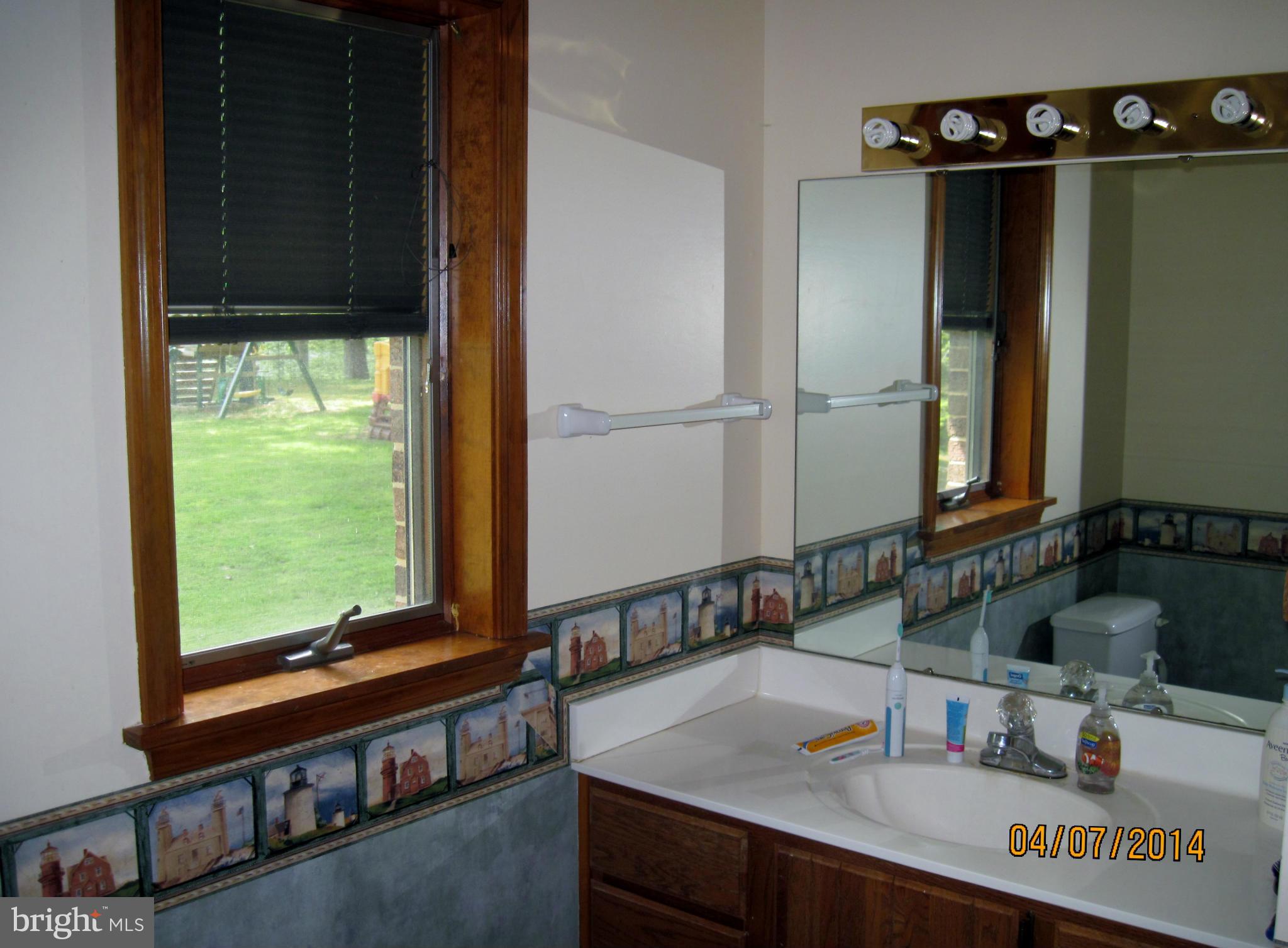7151 Marshall Road St. Leonard, MD 20685 - Photo 17 of 25 a bathroom with a sink and a mirror