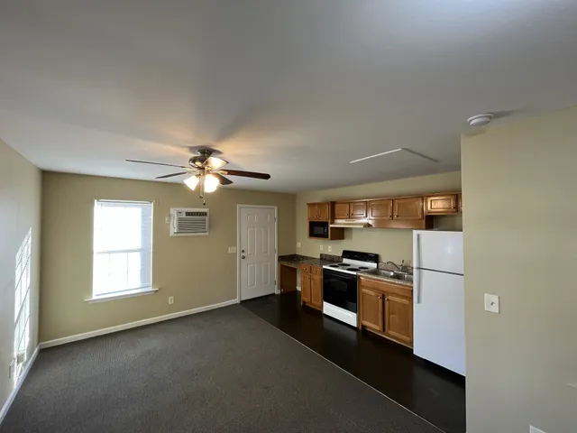 a kitchen with stainless steel appliances granite countertop a refrigerator a stove a sink and a window