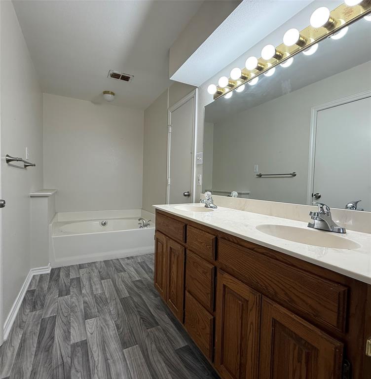313 Pear Tree Place Denton, TX 76207 - Photo 14 of 23 Full bathroom with a garden tub, dark wood-type flooring, and double vanity