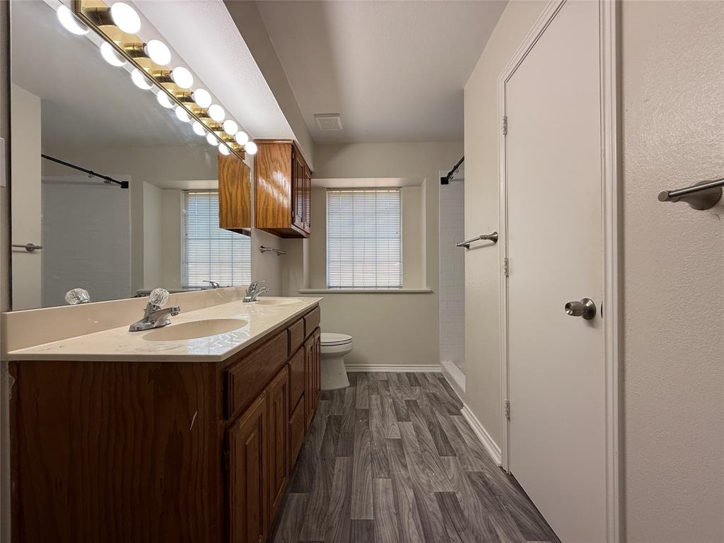 313 Pear Tree Place Denton, TX 76207 - Photo 15 of 23 Bathroom featuring dark wood-style floors, double vanity, and a shower