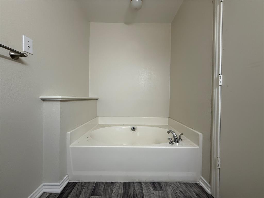 313 Pear Tree Place Denton, TX 76207 - Photo 16 of 23 Bathroom featuring a garden tub and dark wood-style floors