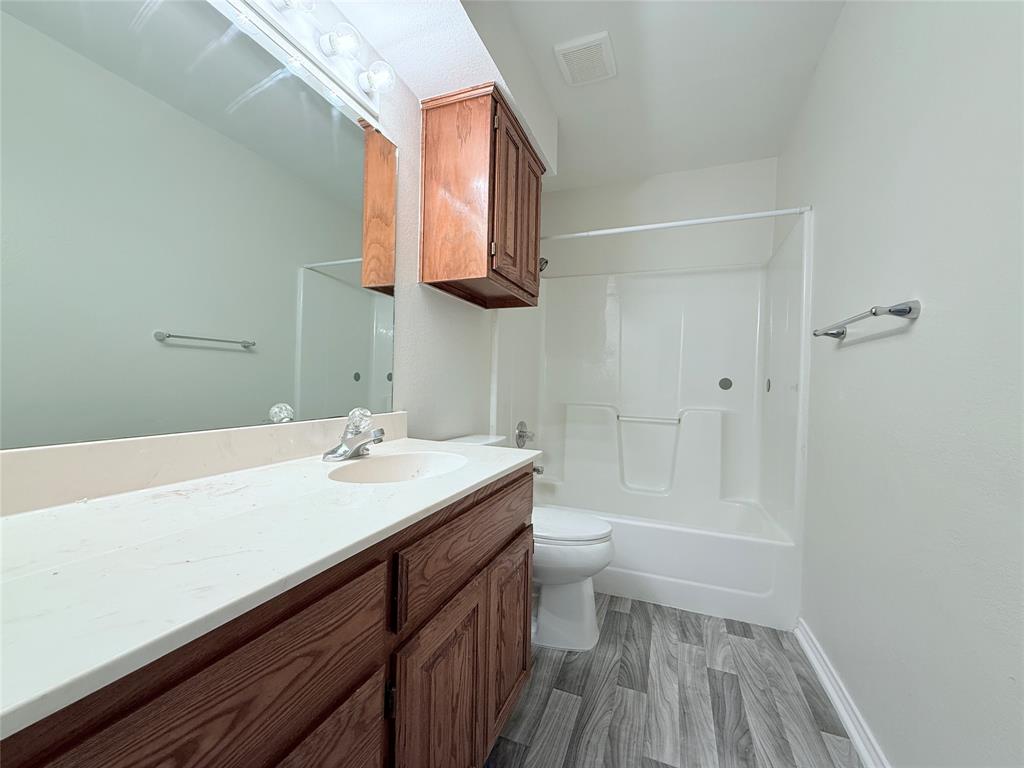 313 Pear Tree Place Denton, TX 76207 - Photo 20 of 23 Bathroom featuring bathing tub / shower combination, vanity, and dark wood finished floors