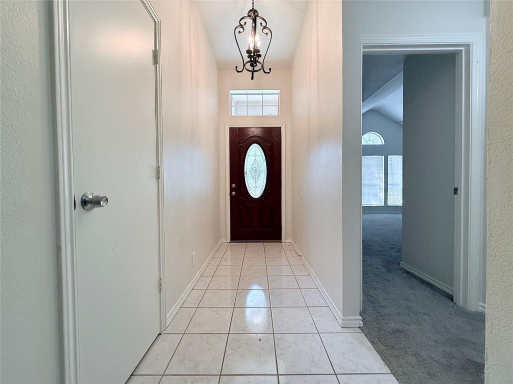 313 Pear Tree Place Denton, TX 76207 - Photo 4 of 23 Foyer entrance with light tile patterned floors, light colored carpet, and a chandelier