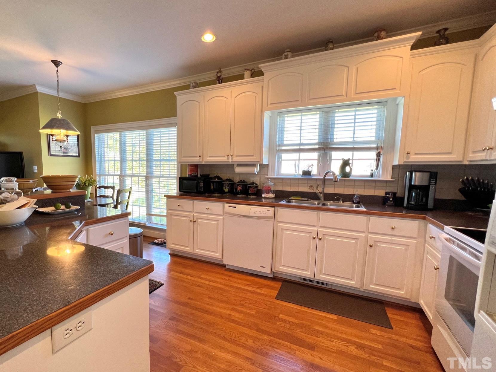 8666 Bailey Road Sims, NC 27880 - Photo 25 of 35 a kitchen with stainless steel appliances granite countertop wooden floors a stove a sink a dining table and chairs