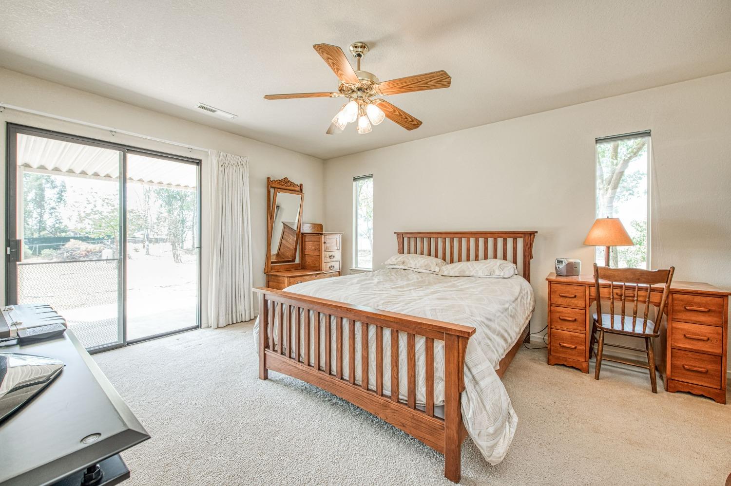 36730 Highway 145 Madera, CA 93636 - Photo 18 of 30 a spacious bedroom with a bed and a chandelier