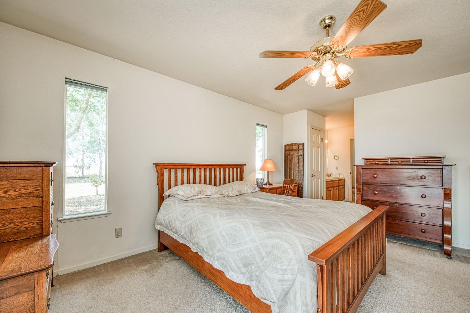 36730 Highway 145 Madera, CA 93636 - Photo 19 of 30 a bedroom with a bed and a chandelier