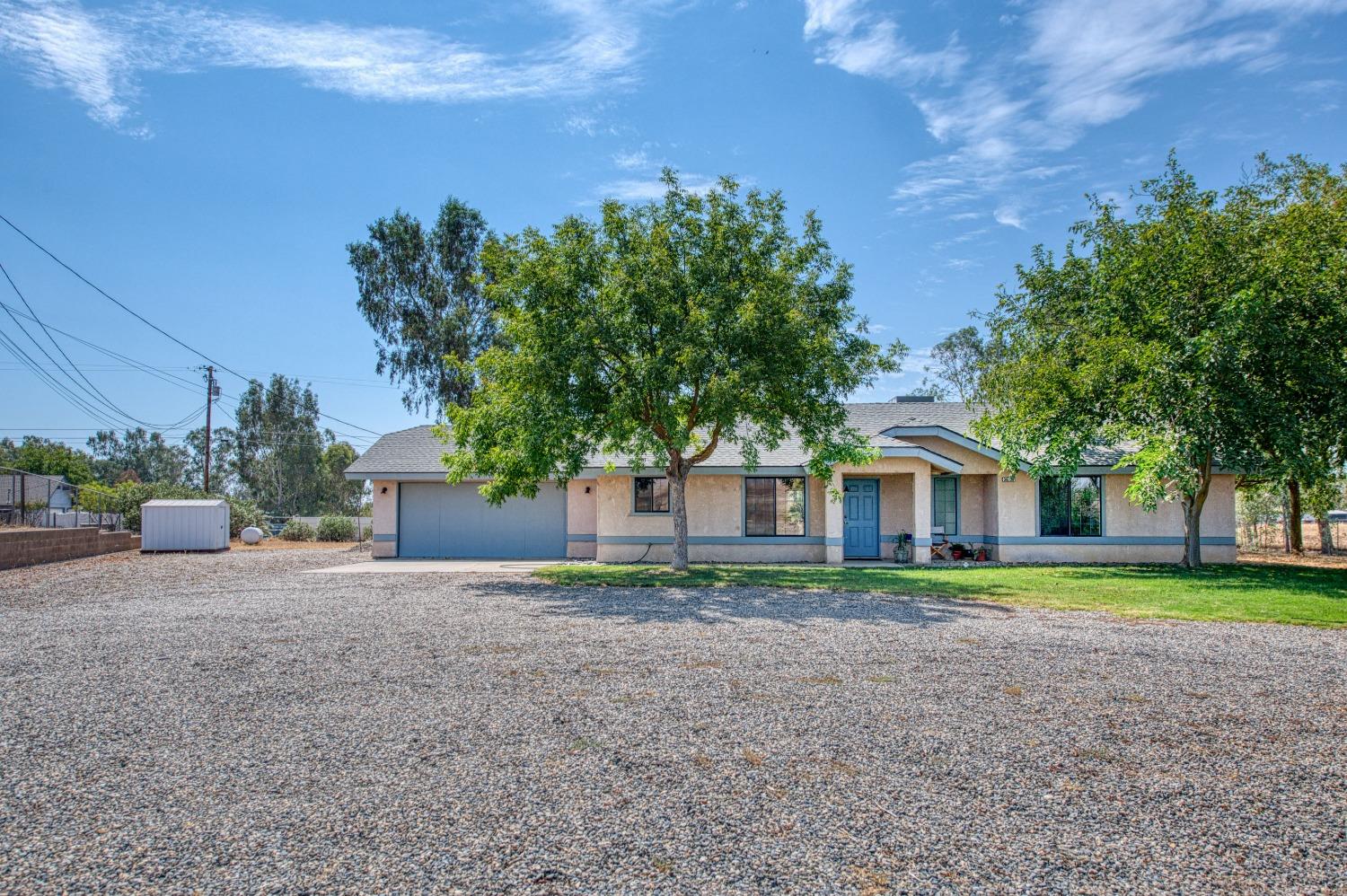 36730 Highway 145 Madera, CA 93636 - Photo 2 of 30 a front view of a house with a yard and trees