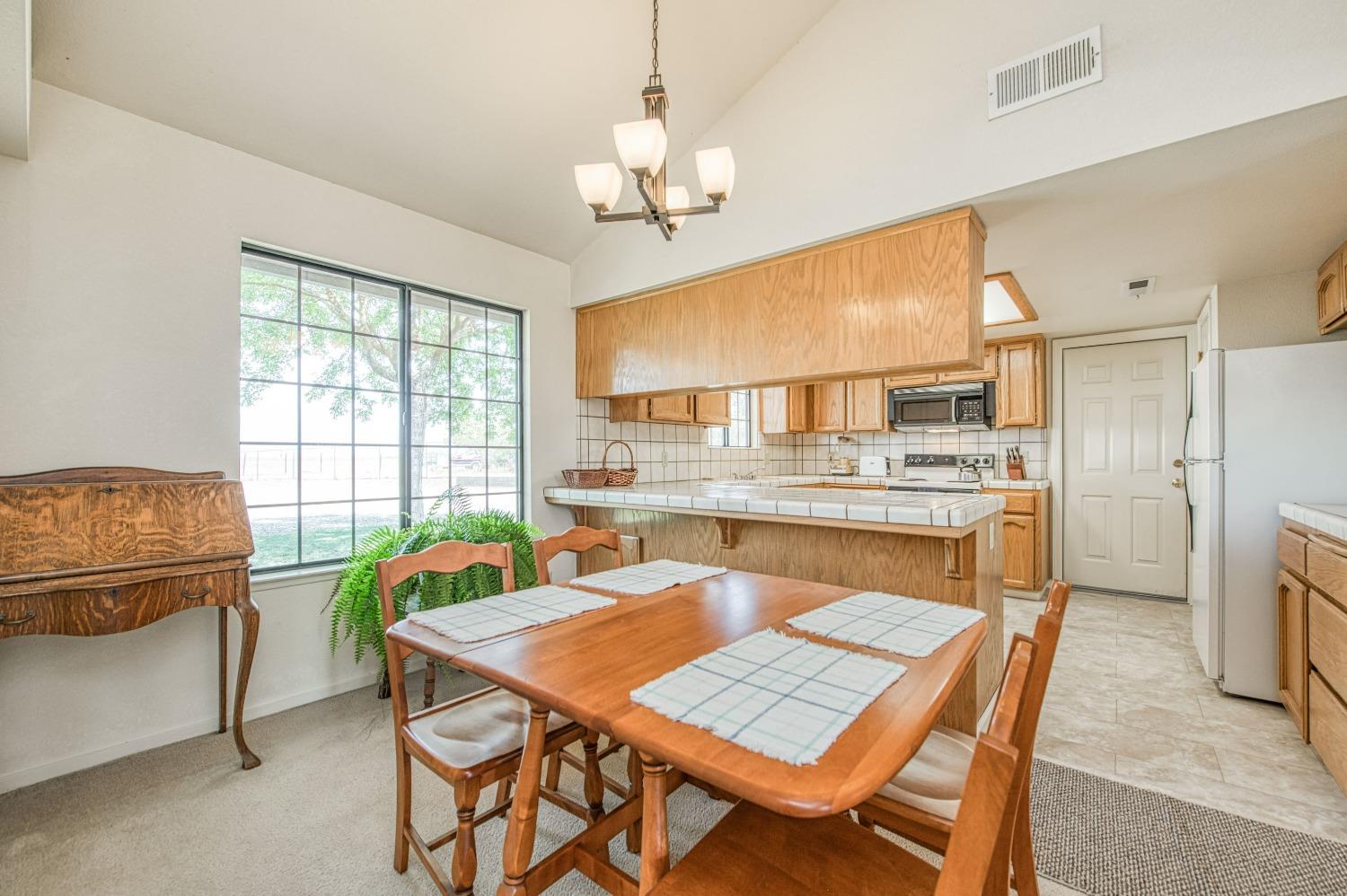 36730 Highway 145 Madera, CA 93636 - Photo 6 of 30 a dining room with a table chairs and a kitchen view