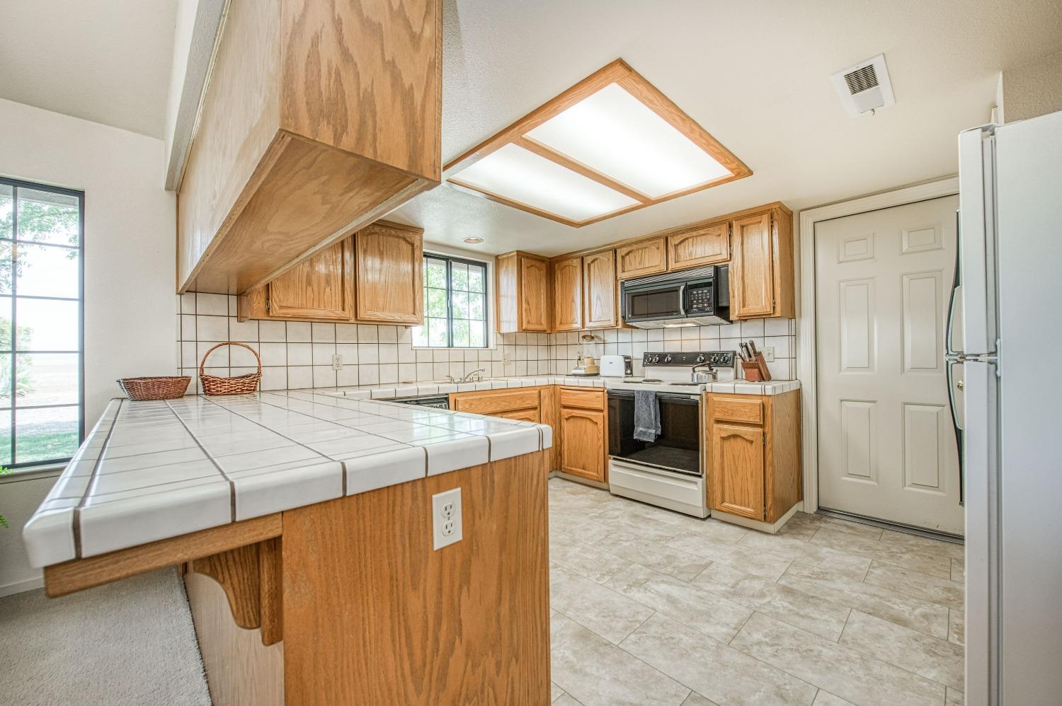 36730 Highway 145 Madera, CA 93636 - Photo 8 of 30 a kitchen with stainless steel appliances kitchen island granite countertop a stove a sink and a refrigerator